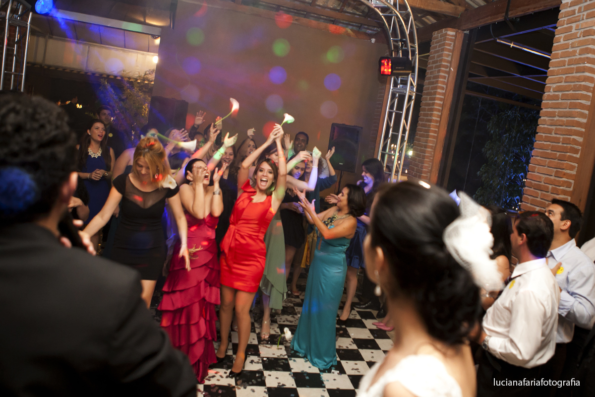 noiva jogando buque de copo de leite buque de santo antônio no casamento madrinhas pegando o buque registro da fotógrafa luciana faria especialista em casamentos