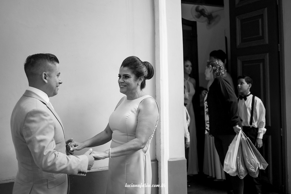 encontro emocionante do noivo com sua mãe na porta da igreja fotografia em pb