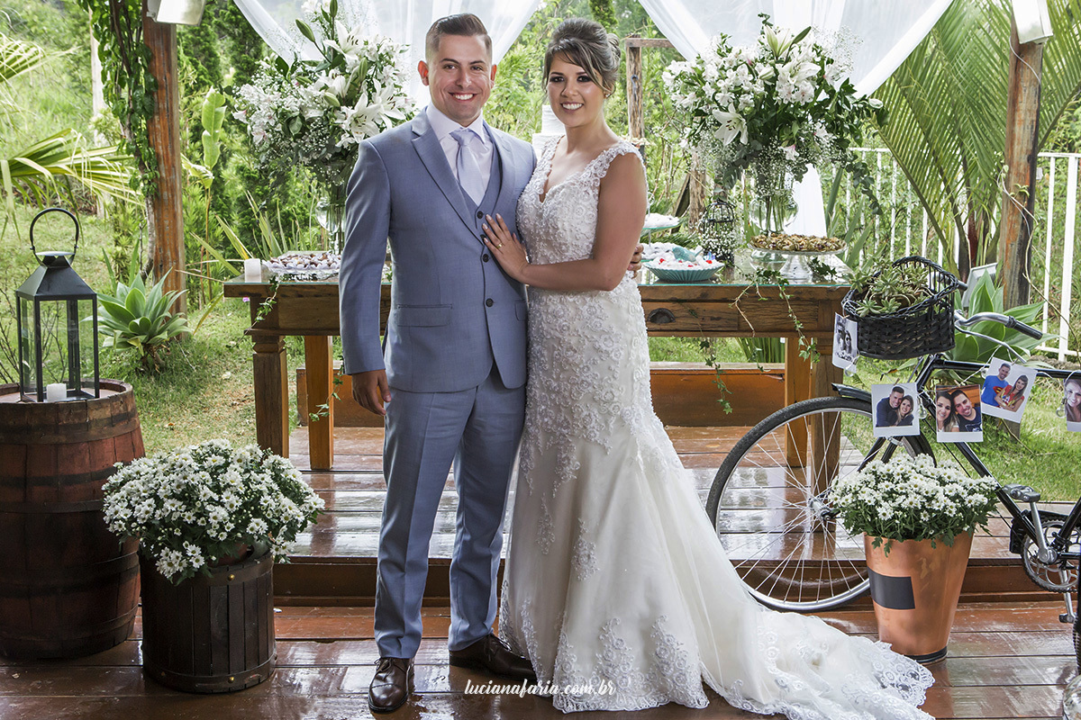 retrato dos noivos em fotografia tradicional de casamento noivos na mesa do bolo decoração feita pela mãe da noiva 
