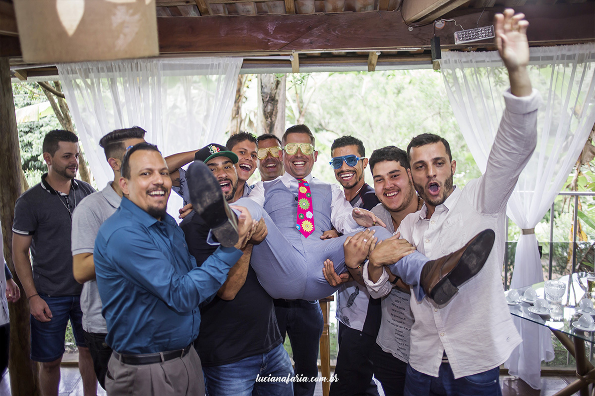 padrinhos segurando o noivo amigos do noivo em fotografia divertida do noivo