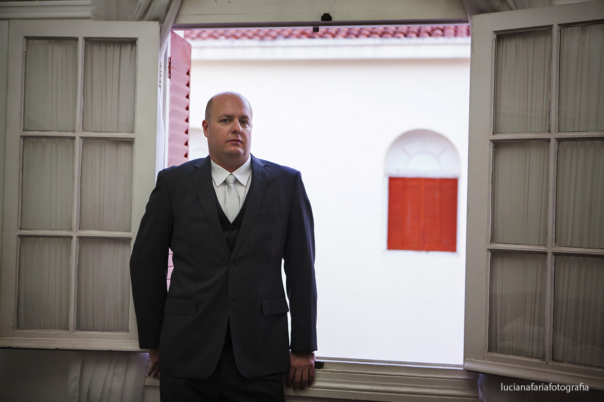 noivo pronto para casar em linda fotografia na janela do hotel foto de Luciana Faria