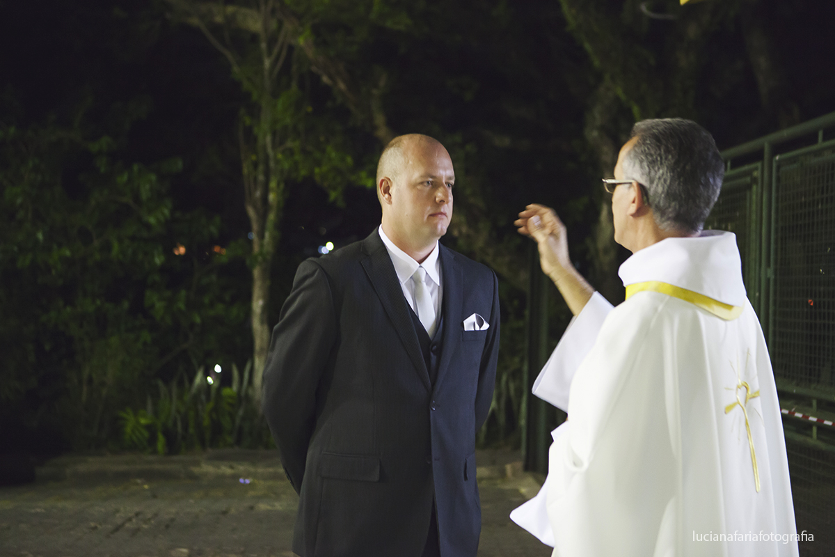 padre abençoando o noivo antes da cerimônia religiosa do casamento na igreja Nossa Senhora de Fátima em Poços de Caldas MG