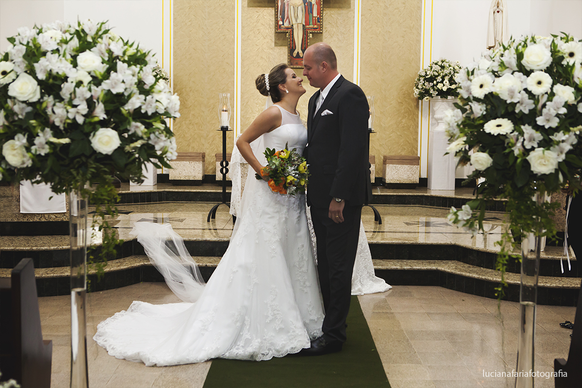 olhar dos noivos momento do beijo do casal na saída da igreja registro fotográfico feito por Luciana Faria fotógrafa de casamento em poços de caldas MG