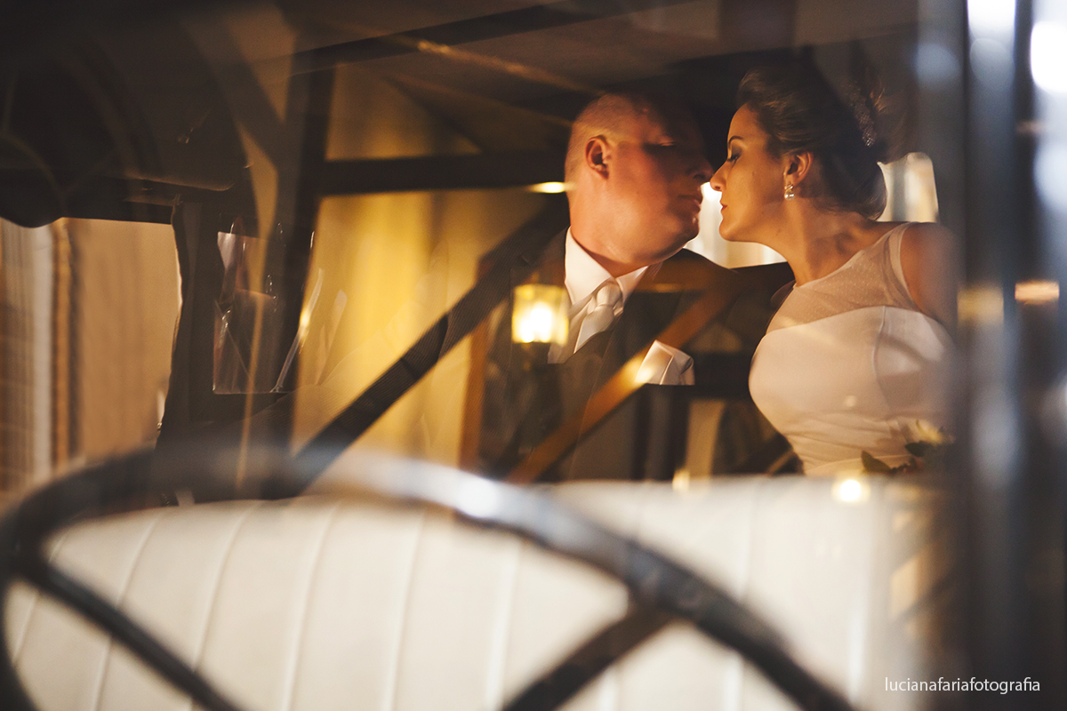fotografia dos noivos no carro antigo noivos posando para a fotógrafa de casamento Luciana Faria na porta do Hotel palace