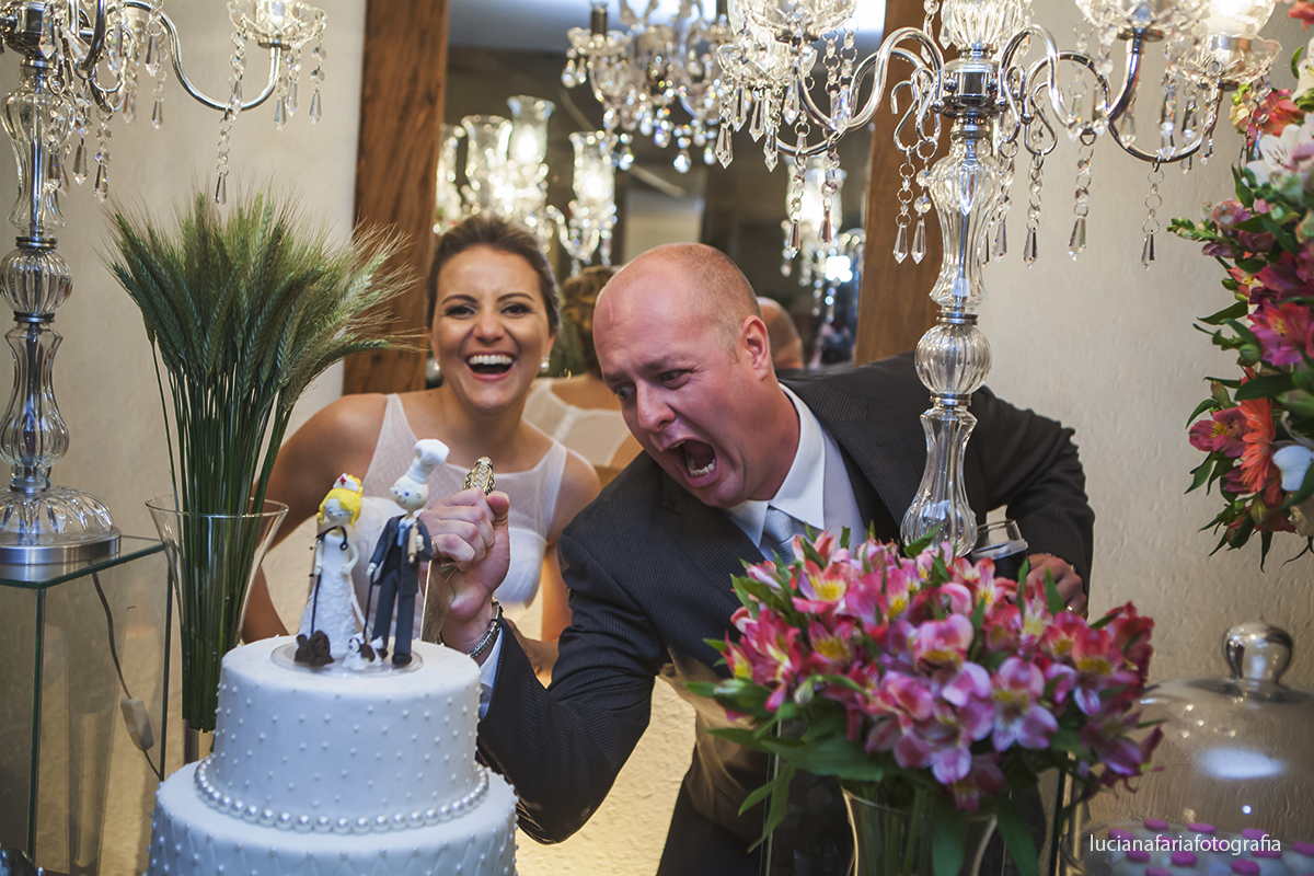mesado bolo foto dos noivos cortando o bolo casal descontraído na festa do casamento fotografado por Luciana Faria no buffe Jefté em Poços de Caldas MG