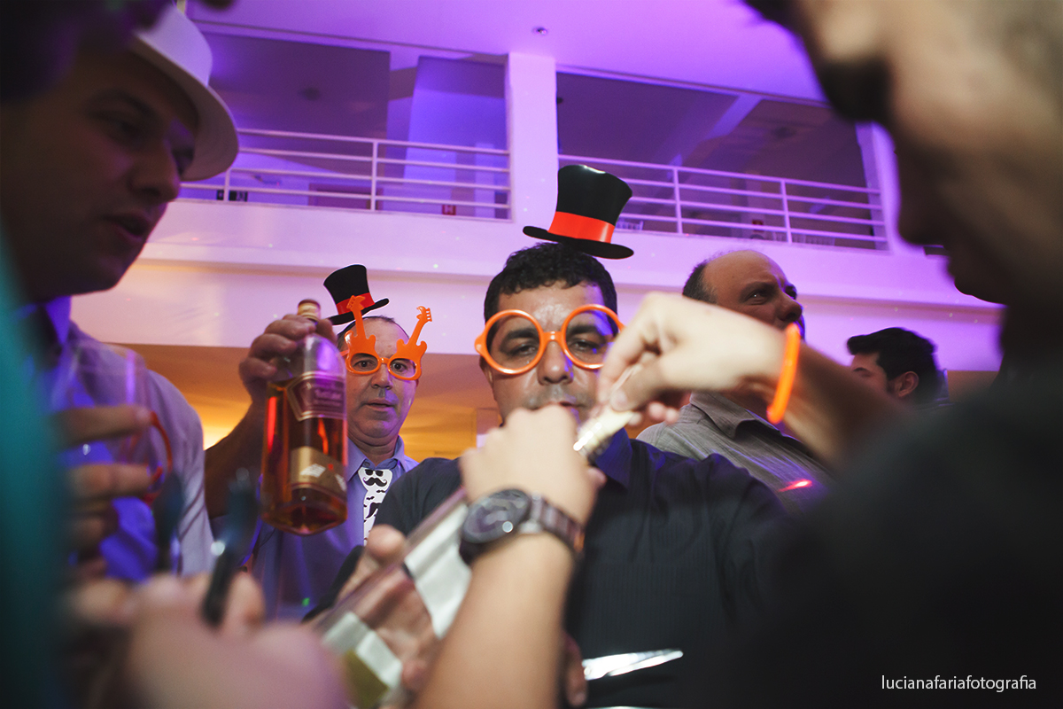 amigos do noivo cortando a gravata fotos da garrafa de whisky na festa do casamento