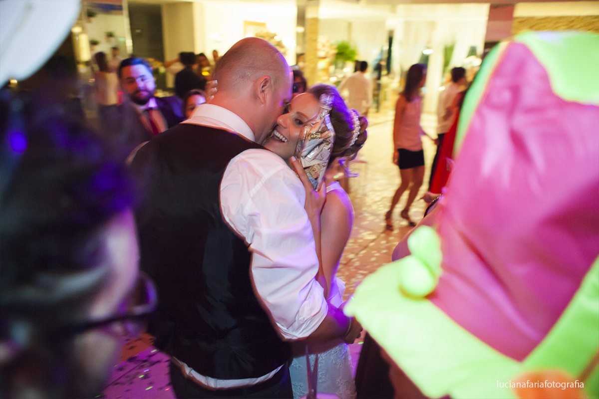 noivos comemorando o corte da gravata com garrafa cheia na festa de casamento