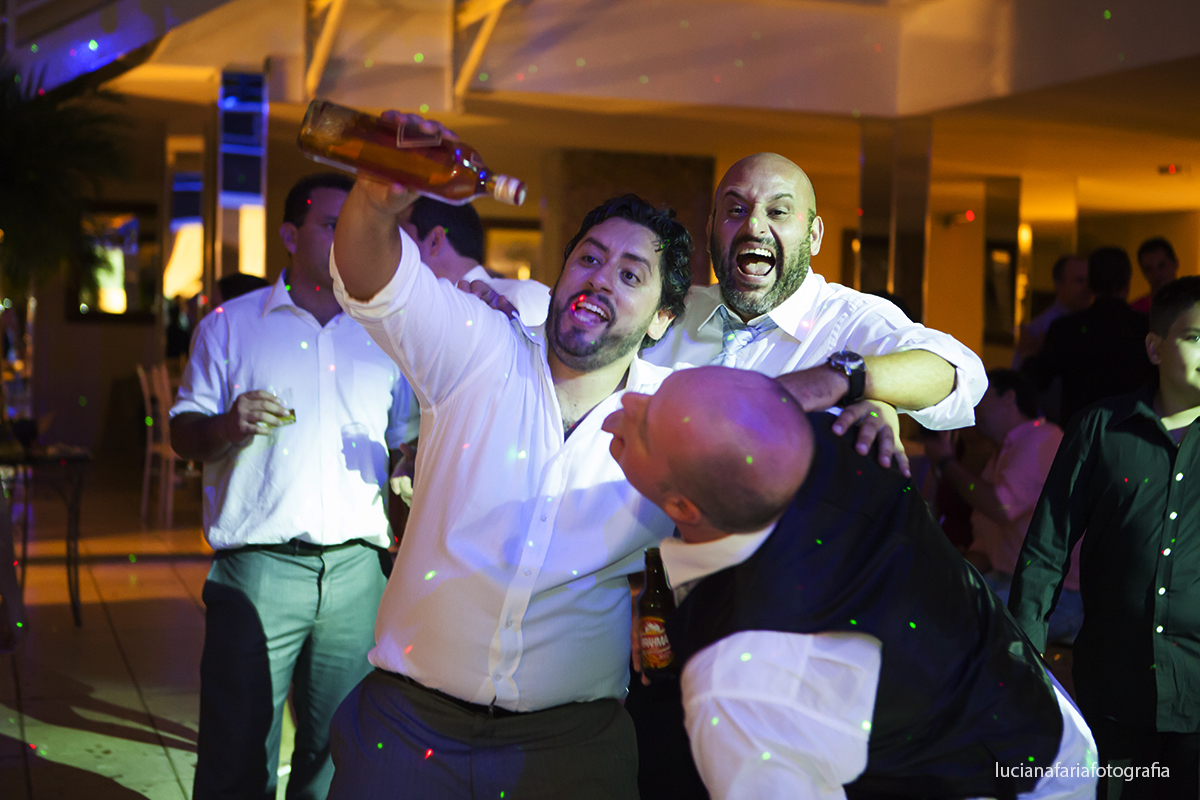 animados amigos do noivo brincam com garrafa de whisky cheia tomando no bico com os amigos