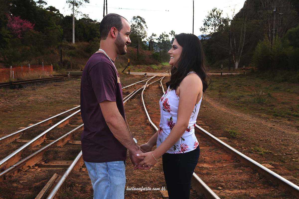na linha do trem de poços de caldas casal de mãos dadas se olham para comemorar uma ano de casados com ensaio fotográfico com luciana faria fotografo poços de caldas