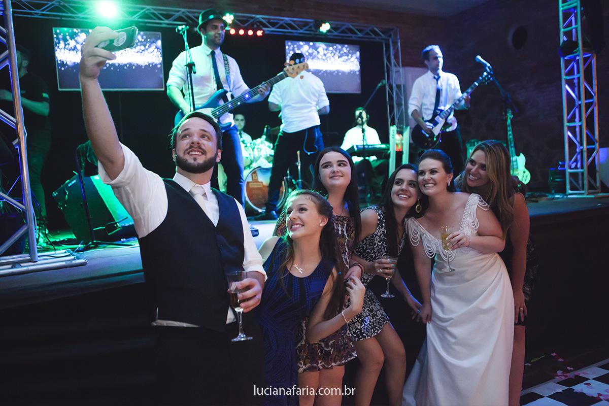 tirando selfie os noivos fazem fotos para guardar de lembrança do dia do casamento na recepção animada com a banda show
