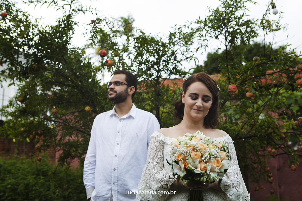 posando para a foto o casal em frente a um pé de romã registrados pela fotógrafa de casamento luciana faria em poços de caldas -mg