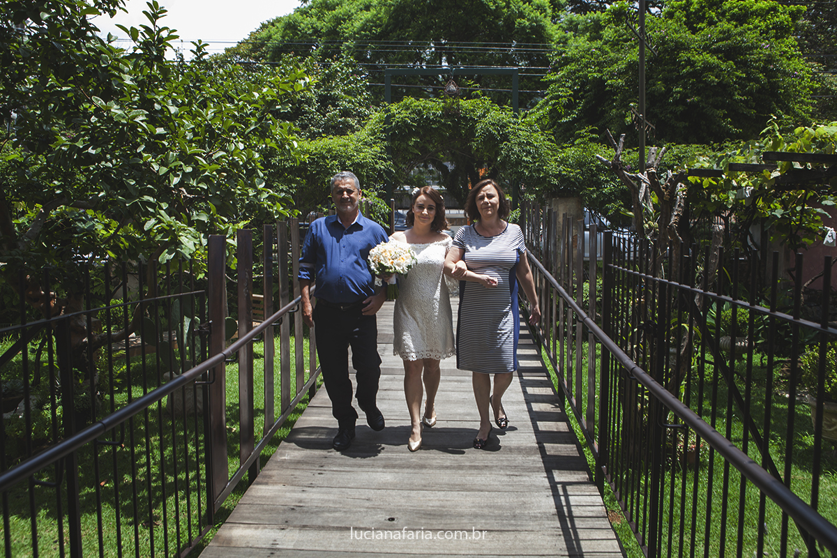 caminhando em direção do altar a noiva com seus pais caminham numa linda foto da fotógrafa de casamento luciana faria