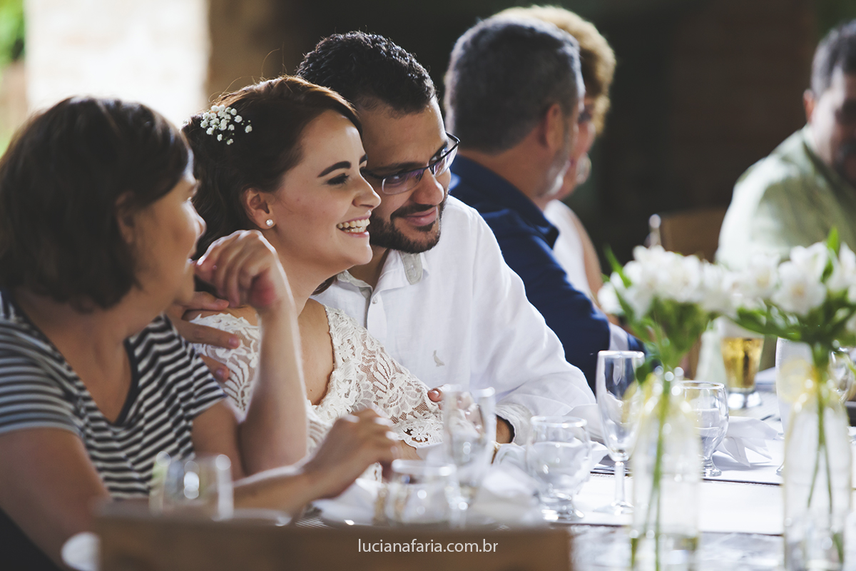 descontração depois da cerimônia do casal que sentados a mesa recebem seus amigos linda fotografia de luciana faria