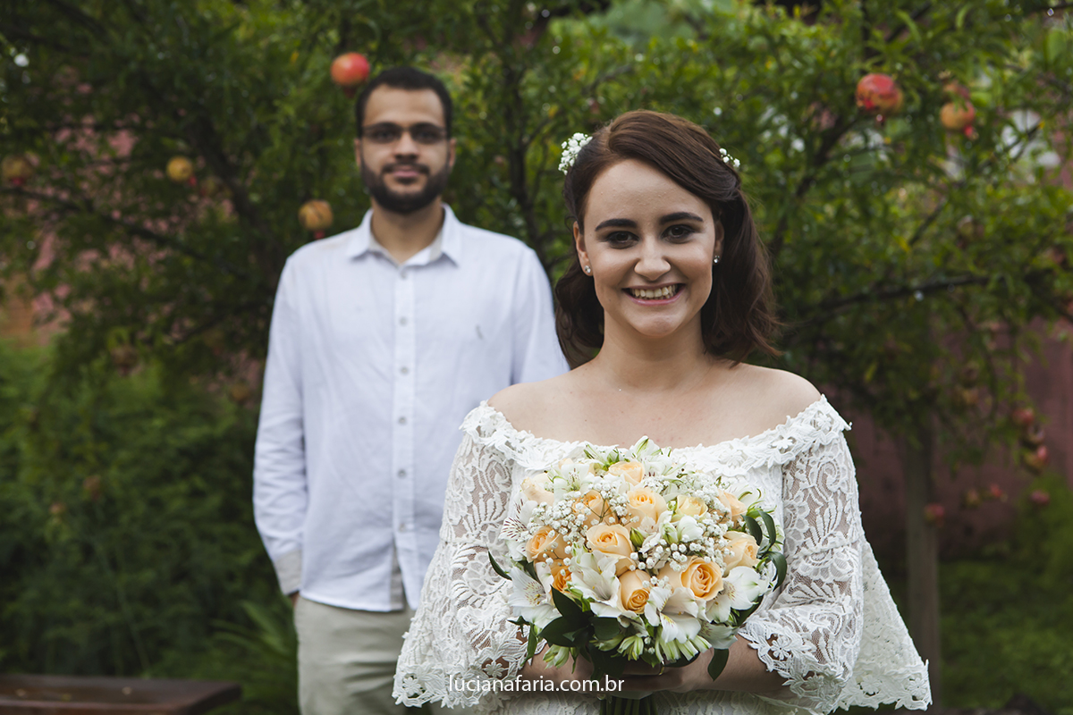 atrás dos noivos pé de romã com frutas maduras noivos fazem fotos posadas do dia do casamento com luciana faria