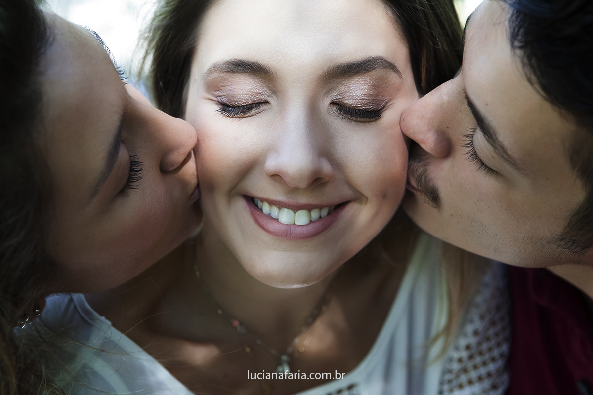 beijo sanduíche dos irmãos para a fotografia do book da família