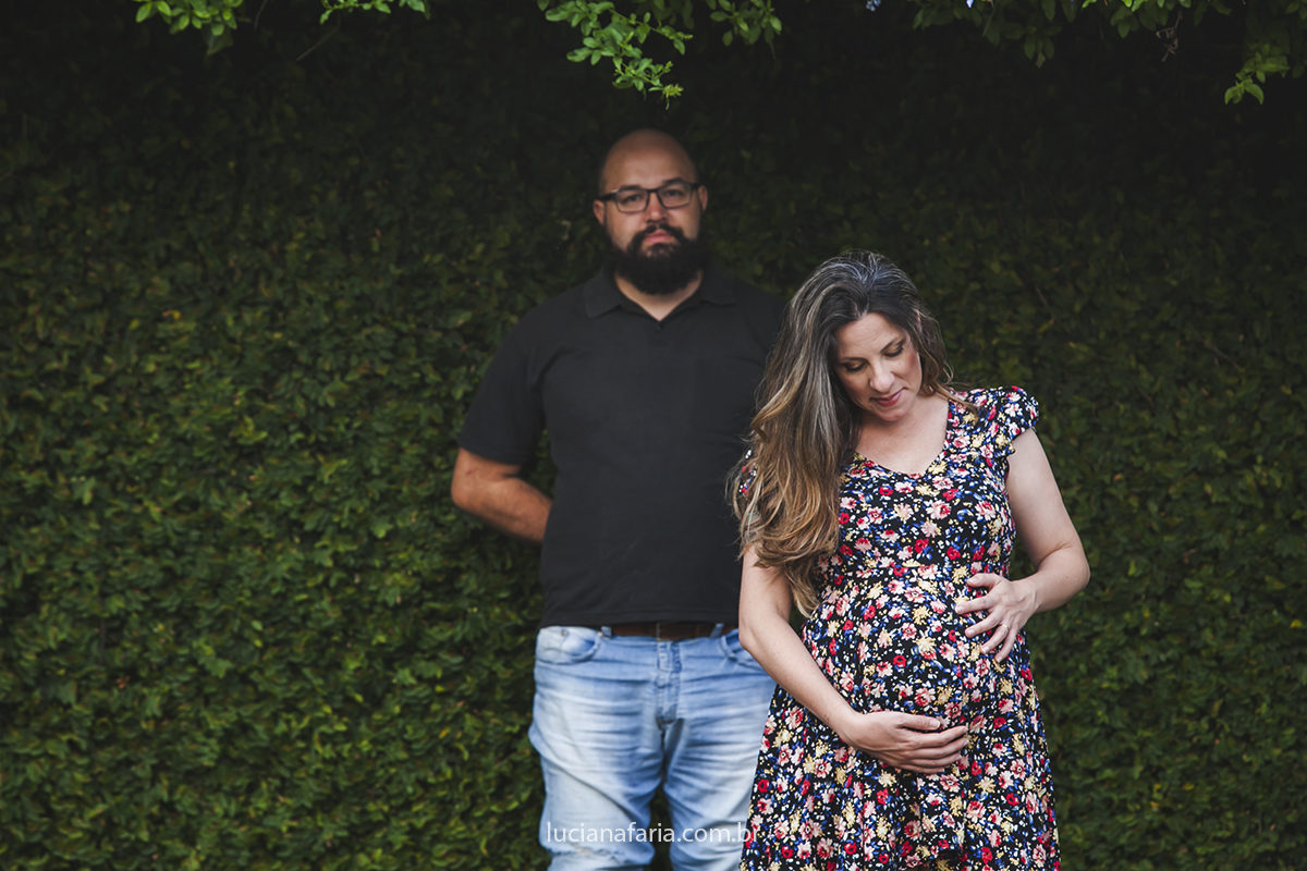 com lindo vestido florido a mamãe acaricia sua barriga de gravida em foto
