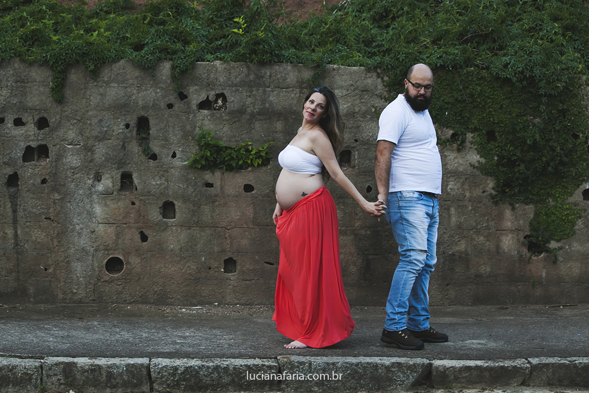 na calçada no fim da tarde casal passeia para ensaio da gestação