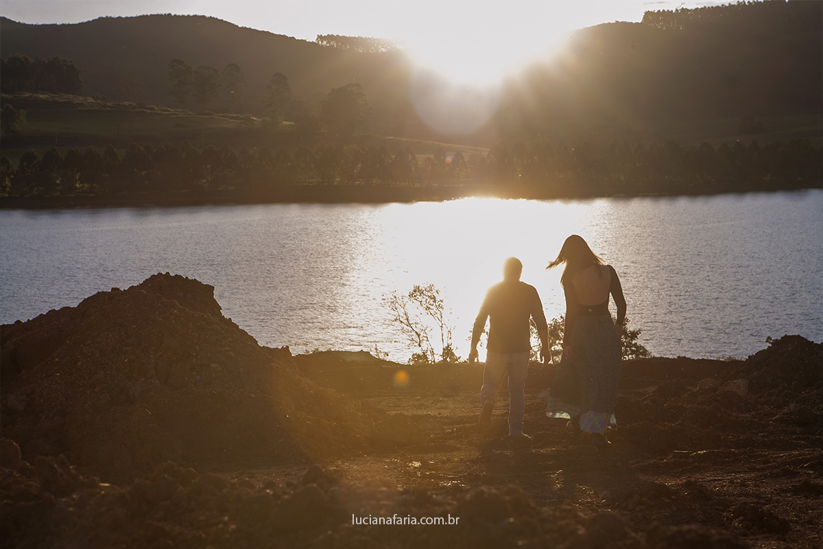 casal caminhando em lindo fim de tarde ao por do sol a fotógrafa de ensaios em poços de caldas luciana faria