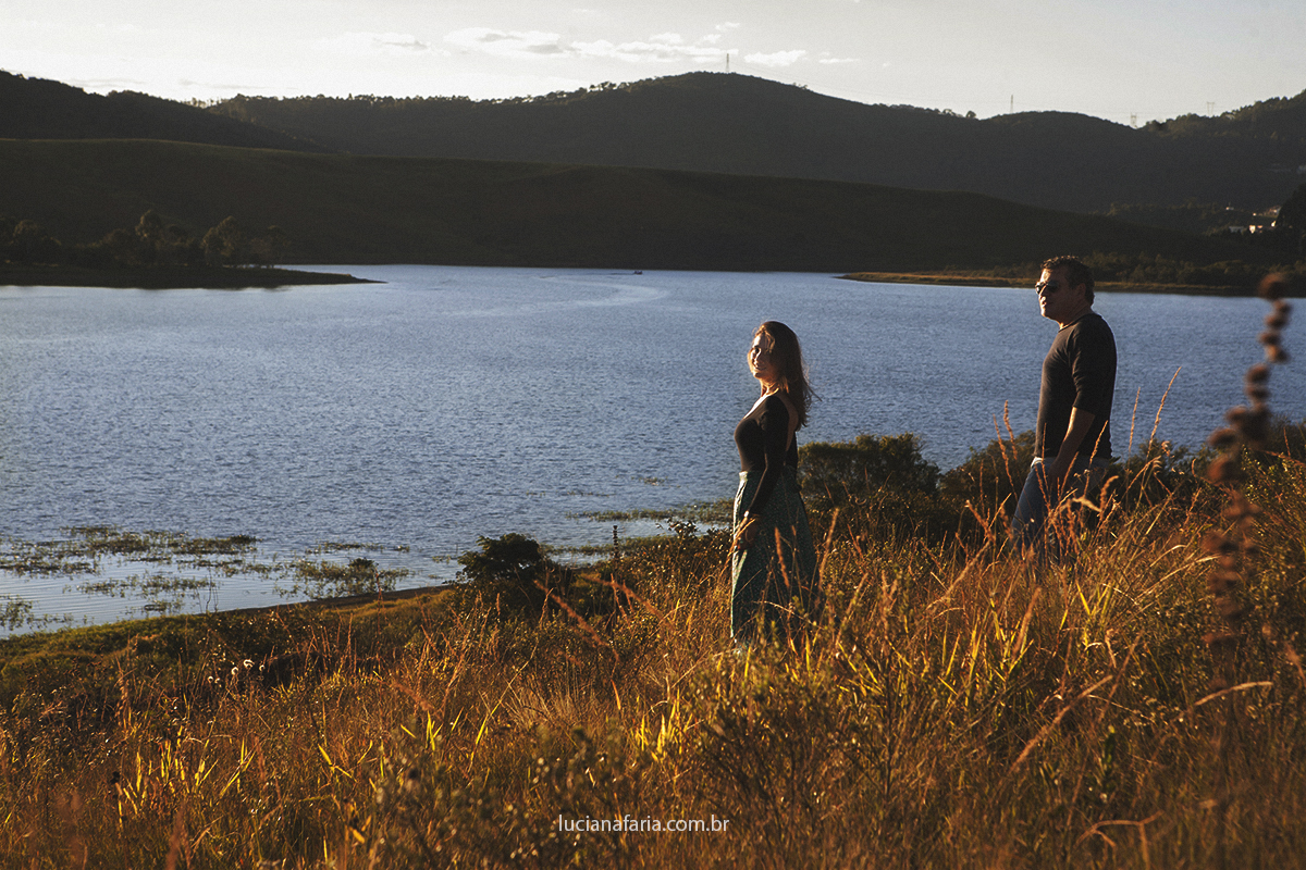pose para a foto em meio ao capim avermelhado da luz do sol os noivos registrados por luciana faria ftografa de casamento em poços de caldas minas