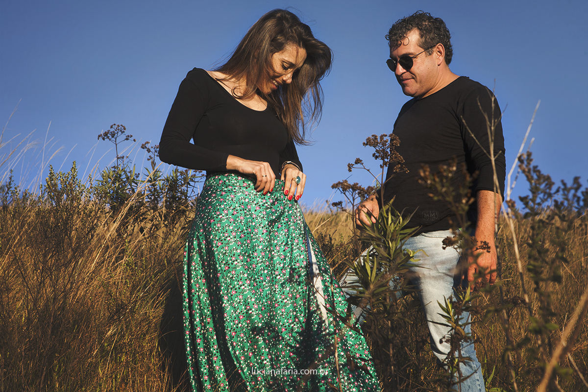 arrumando a saia longa florida roupa para o ensaio pré casamento no dia de inverno registrado pela fotógrafa de poços de caldas luciana faria fotografia
