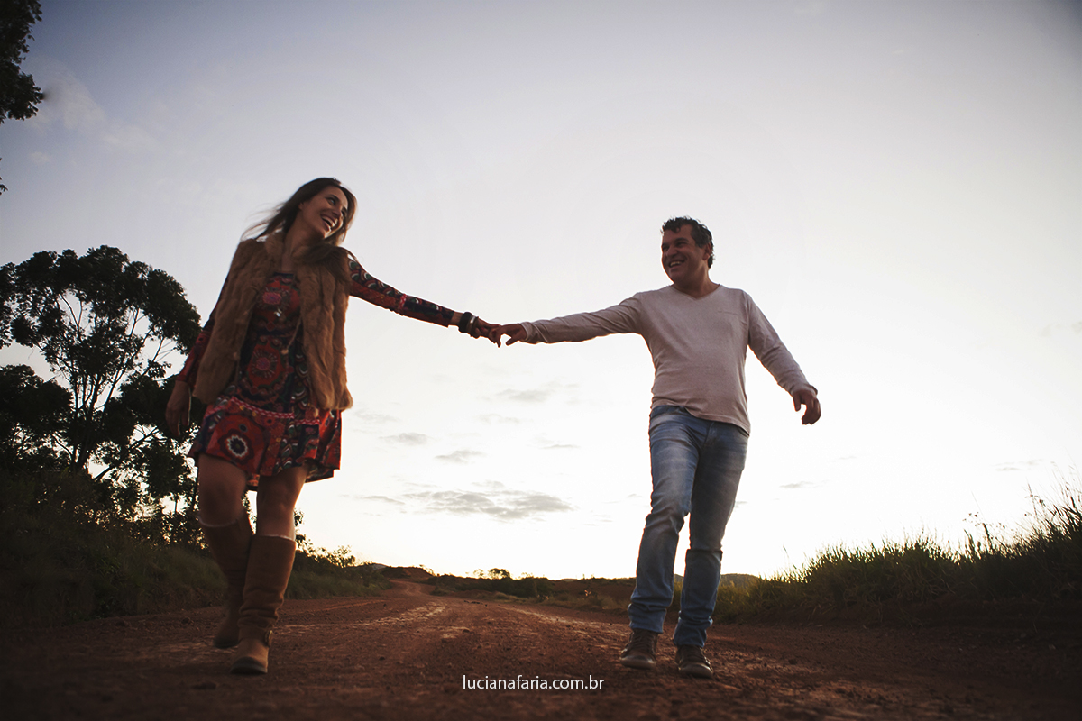de mãos dadas os noivos caminham sorrindo na fotografia pré casamento em poços de caldas mg