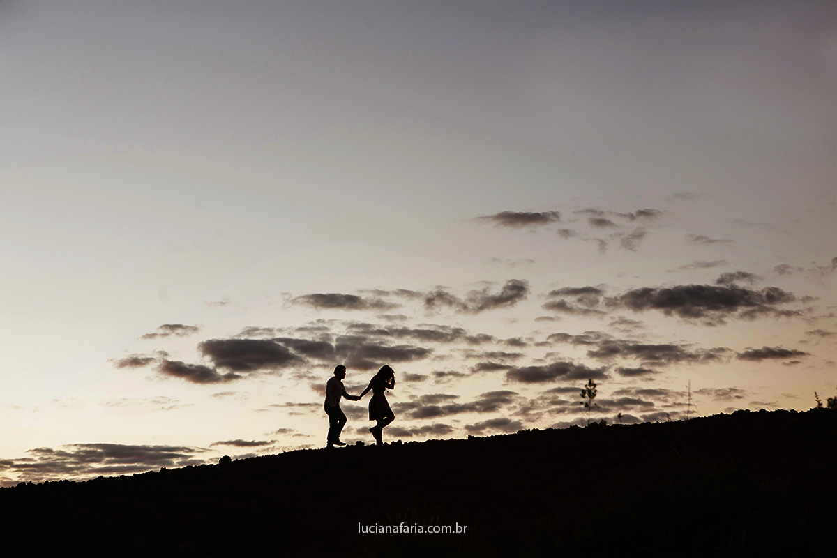 por do sol noivos caminham em foto de silhueta registro feito pela fotografa luciana faria na serra