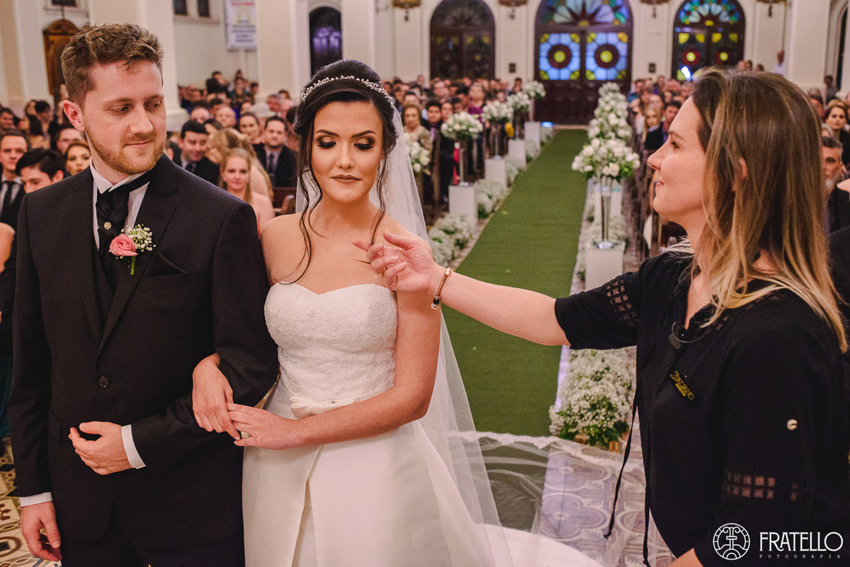 cerimonialista do casamento prestando assistencia para a noiva durante a cerimonia de casamento na igreja matriz nossa senhora da luz em irati