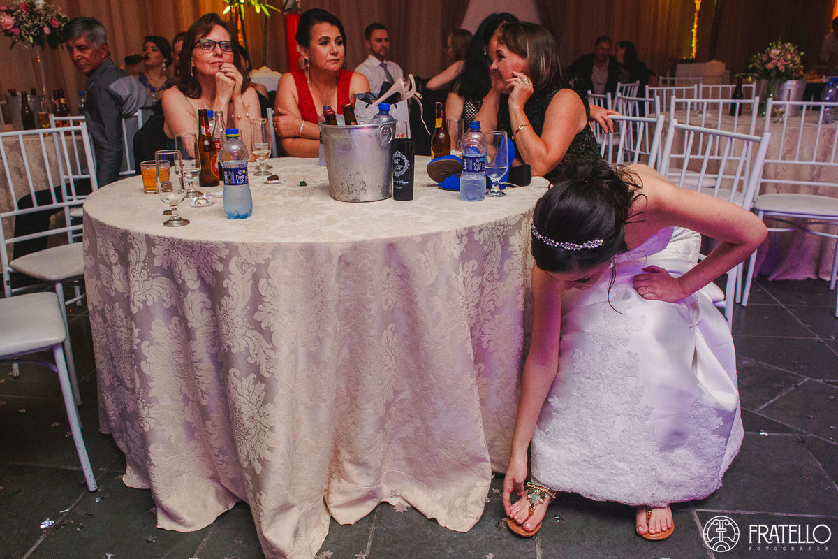 noiva com o pe machucado de tanto dancar na festa de casamento no centro de eventos italiano em irati