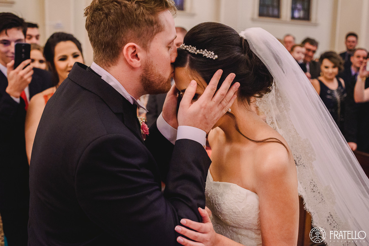 noiva dentro da igreja matriz nossa senhora da luz em irati sendo recebida pelo noivo com beijo na testa no casamento