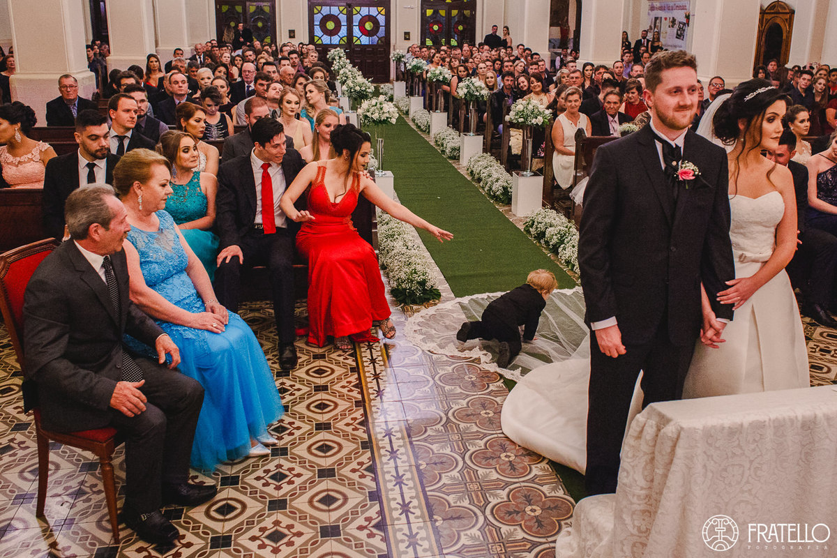 noivinho caindo em cima do veu do vestido da noiva durante a cerimonia do csasamento na igreja matriz nossa senhora da luz em irati