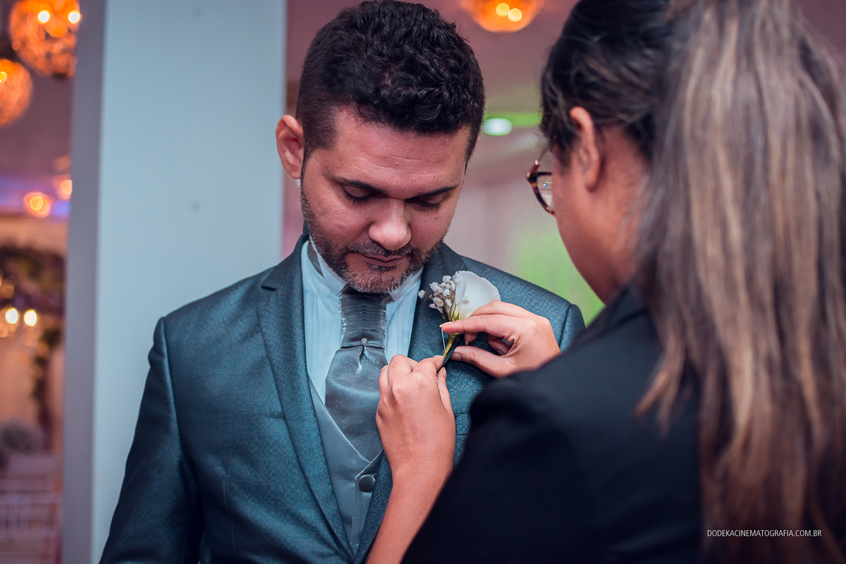 Fotografia de casamento em Manaus do enlace matrimonial de Patricia e Josimar. Cerimonial colocando lapela no noivo.