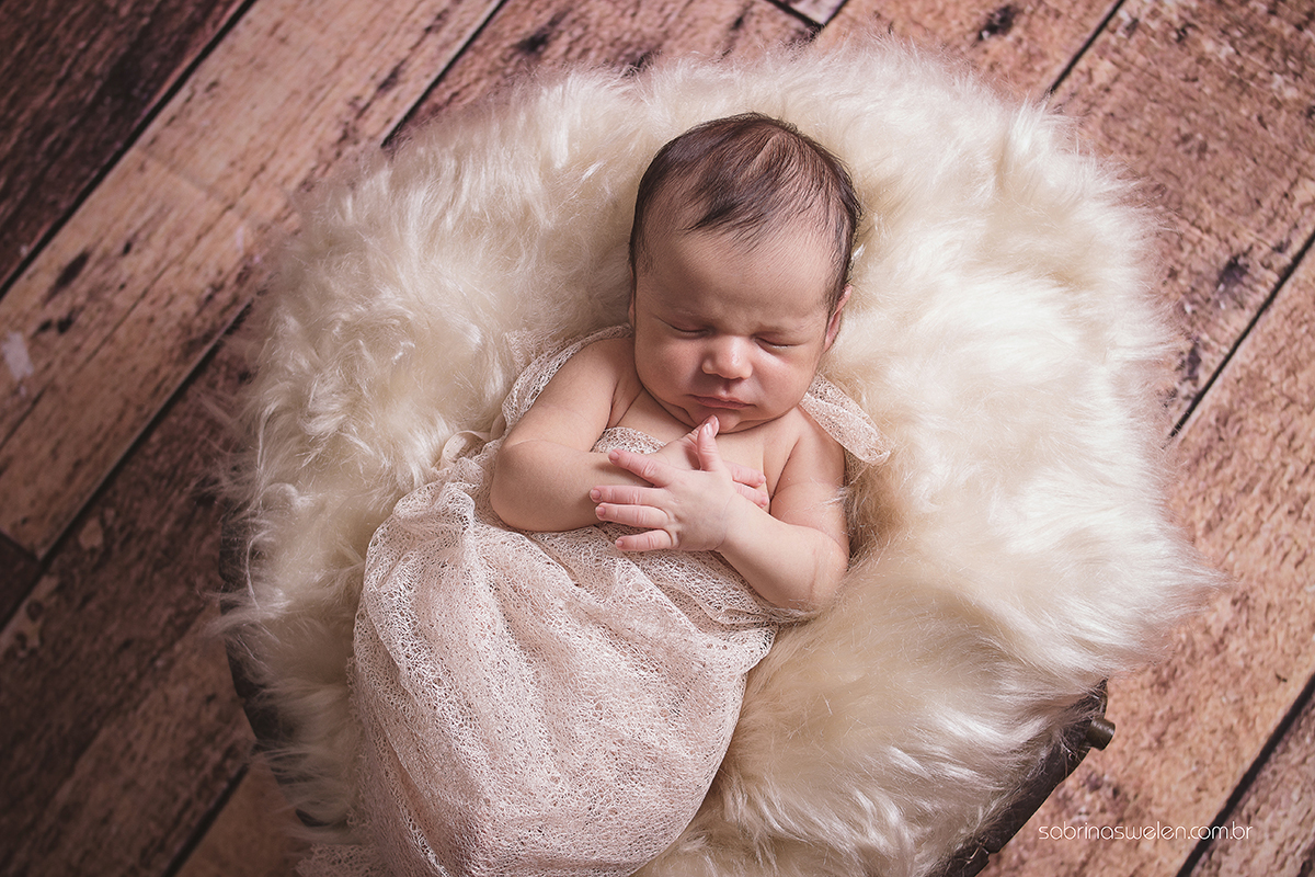 sabrina swelen, newborn, recém nascido, foto de cima para baixo, bebe com as mãos no peito, agradecimento, ensaio newborn em paulista, newborn em recife, fotos de bebe fundo de madeira, tina escura wrap bege  mae de menino bebe fofo newborn top