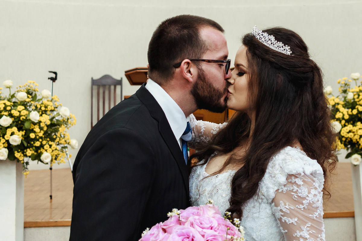 Noivos se beijando depois do sim do pastor em casamento