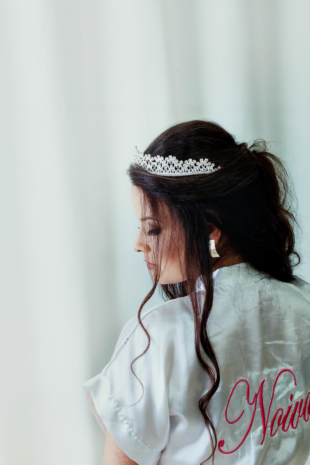 Noiva pousando para foto olhando para o ombro com um vestido branco lindo