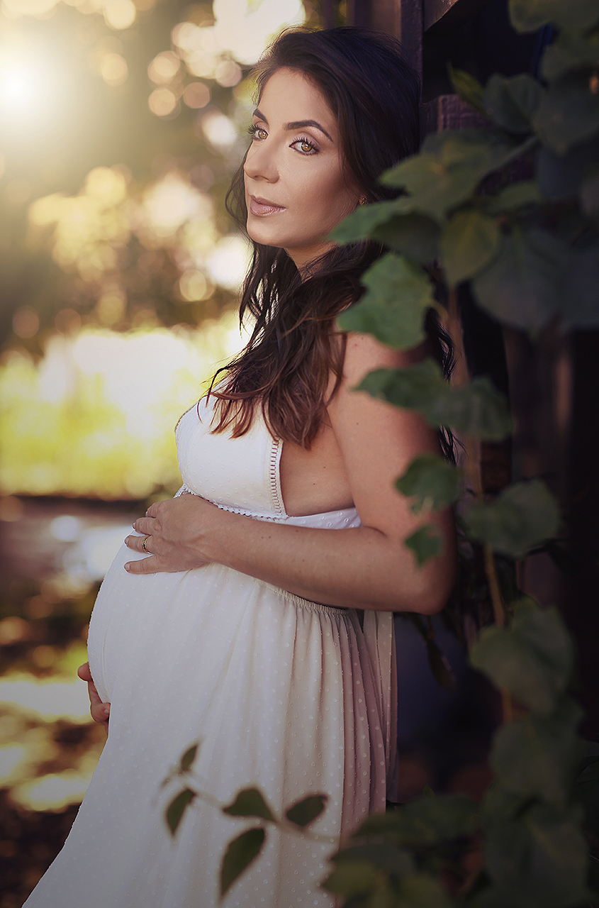 gravida ao lado de galhos de folhas verdes