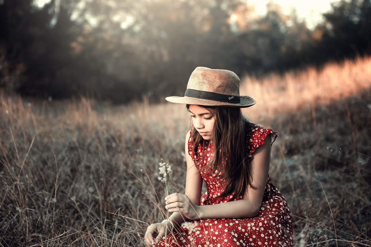 giovana-vestido-vermelho-de-chapeu-brincando-com-uma-flor-ensaio-fotografico-cumbuco