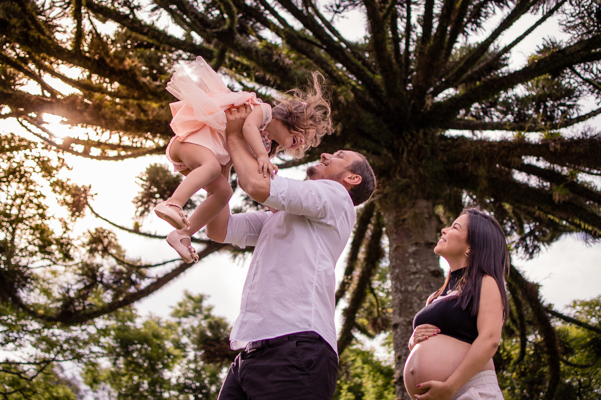 ensaio de gestante casal brincando com a filha mais velha
