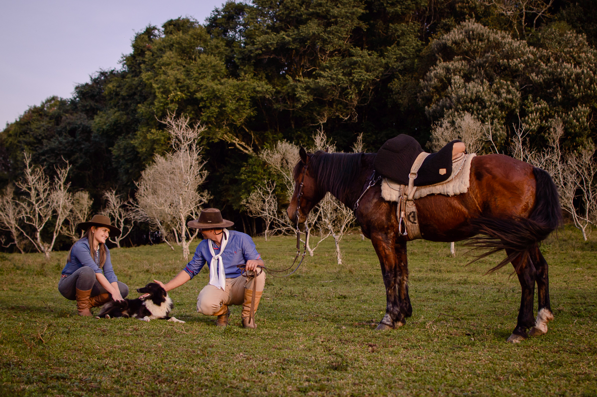 casal fotografando no campo com seu cavalo 