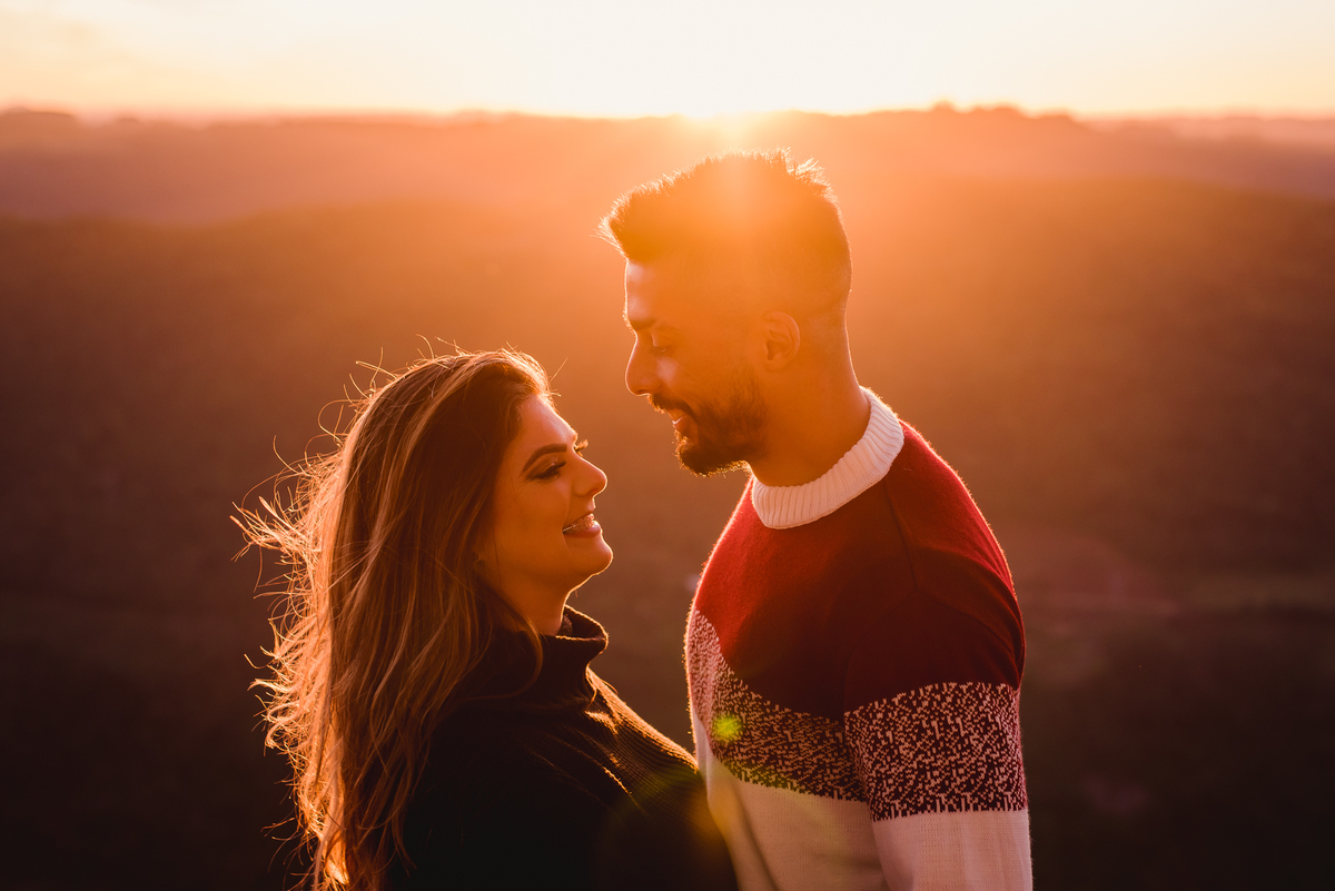 casal no pico de monte claro com o por do sol 
