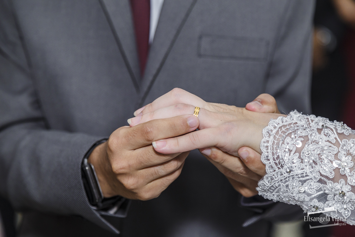 Noivo colocando a aliaça na noiva