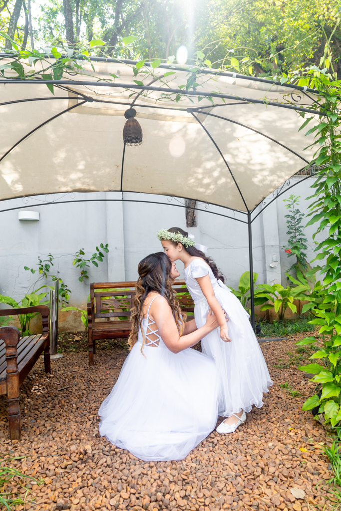 Noiva e daminha beijando sua testa