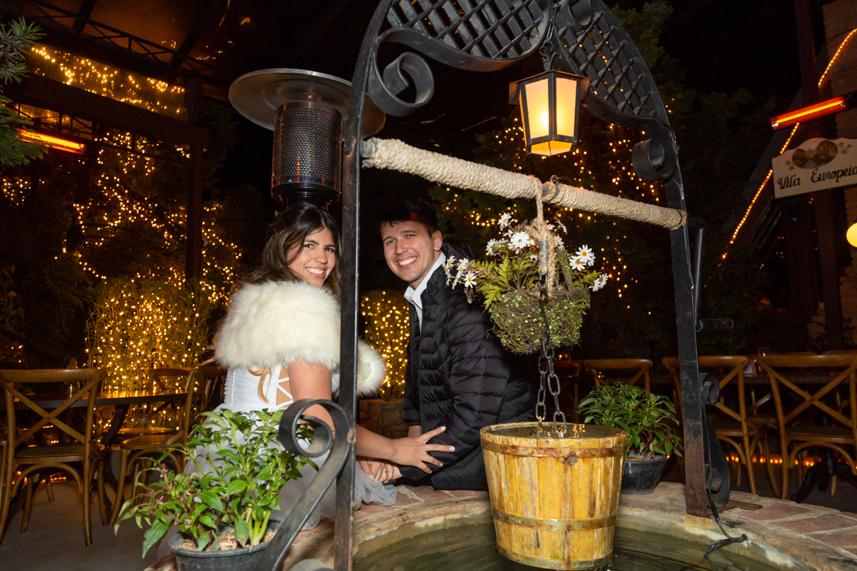 Noivos sentados na beira poço