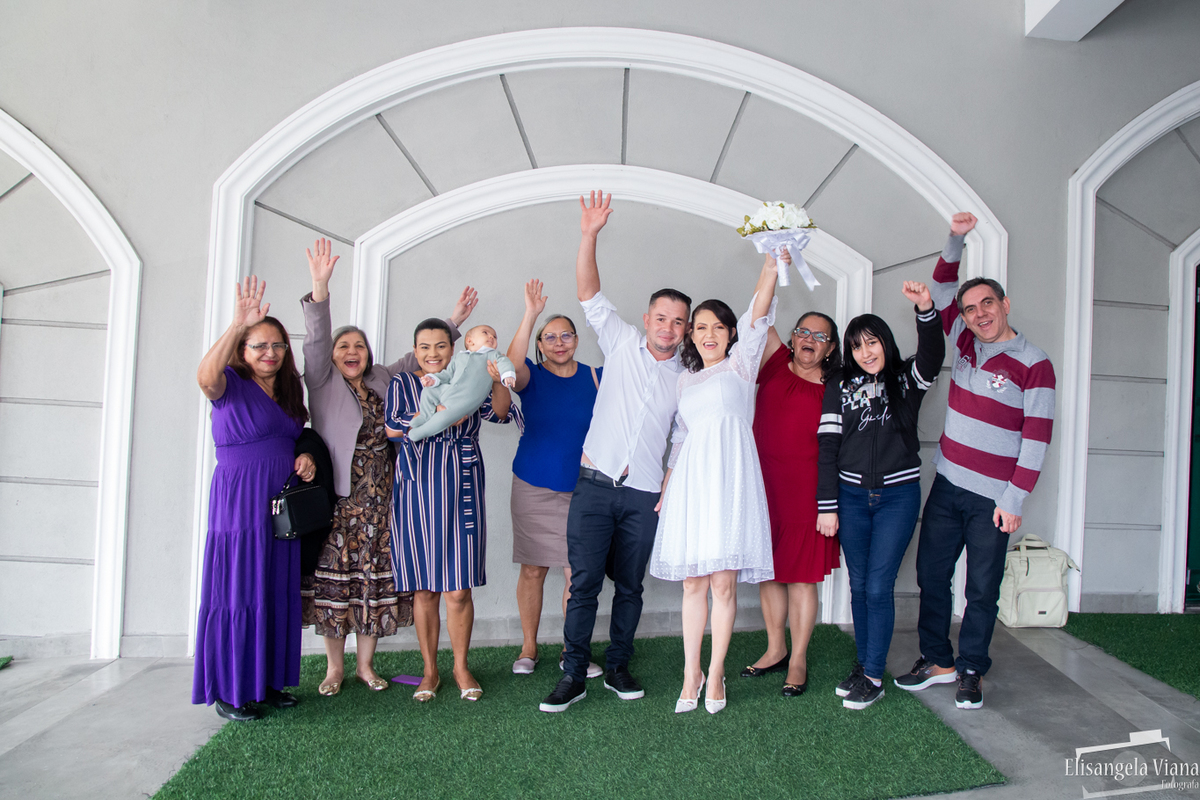 todos convidados comemorando com as mãos para cima