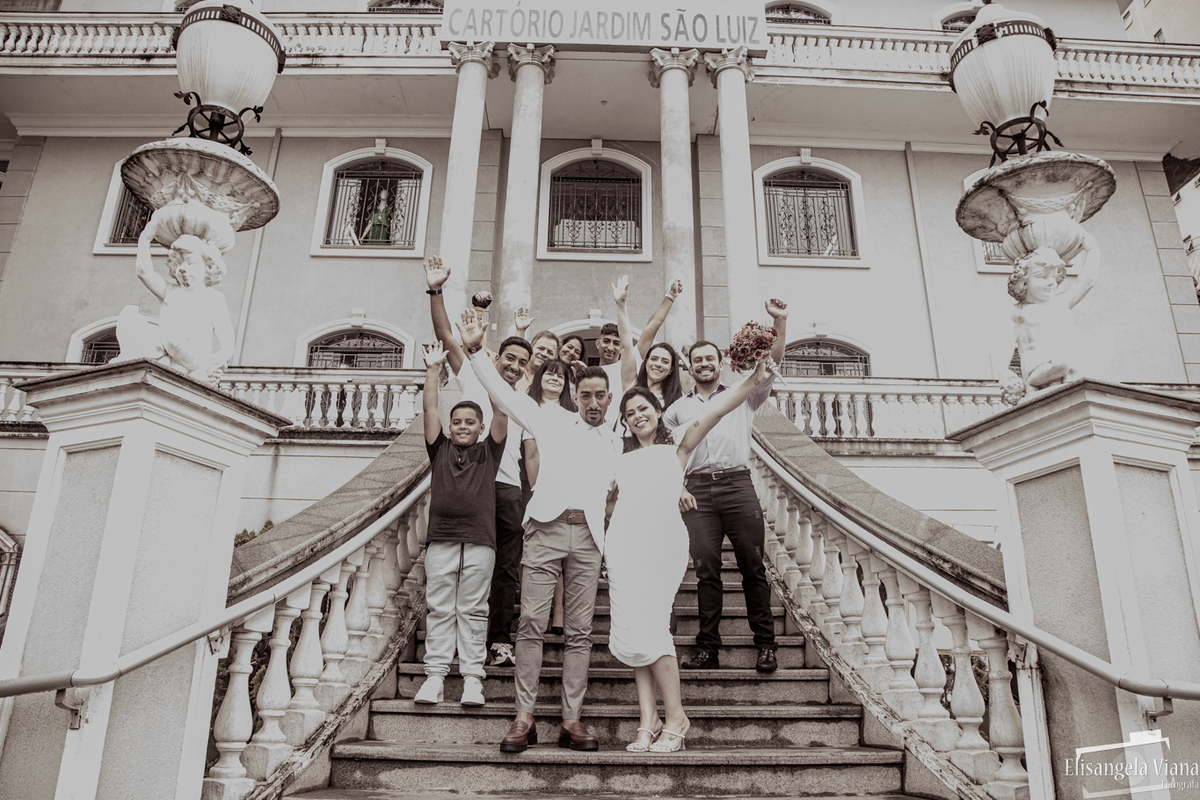 família reunida na escada com as mãos levantadas