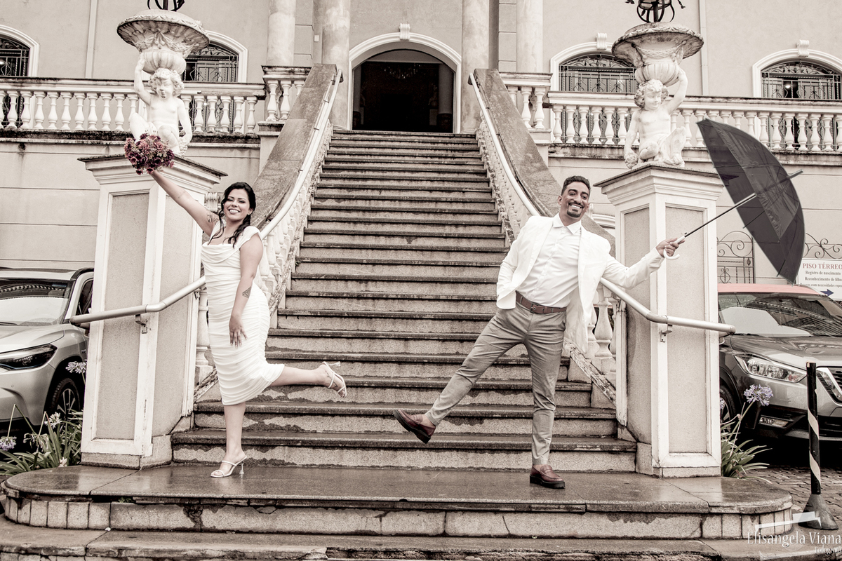 noivos retratam o filme cantando na chuva segurando guarda chuvas