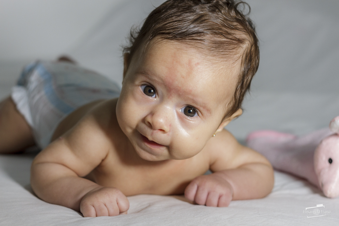 bebê de barriga para baixo com pescoço levantado