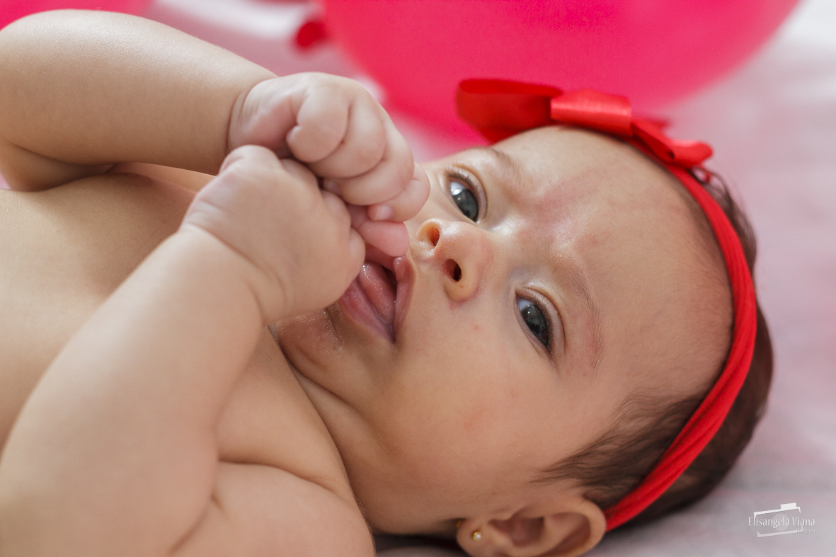 beb~e deitada com as mãos no peito