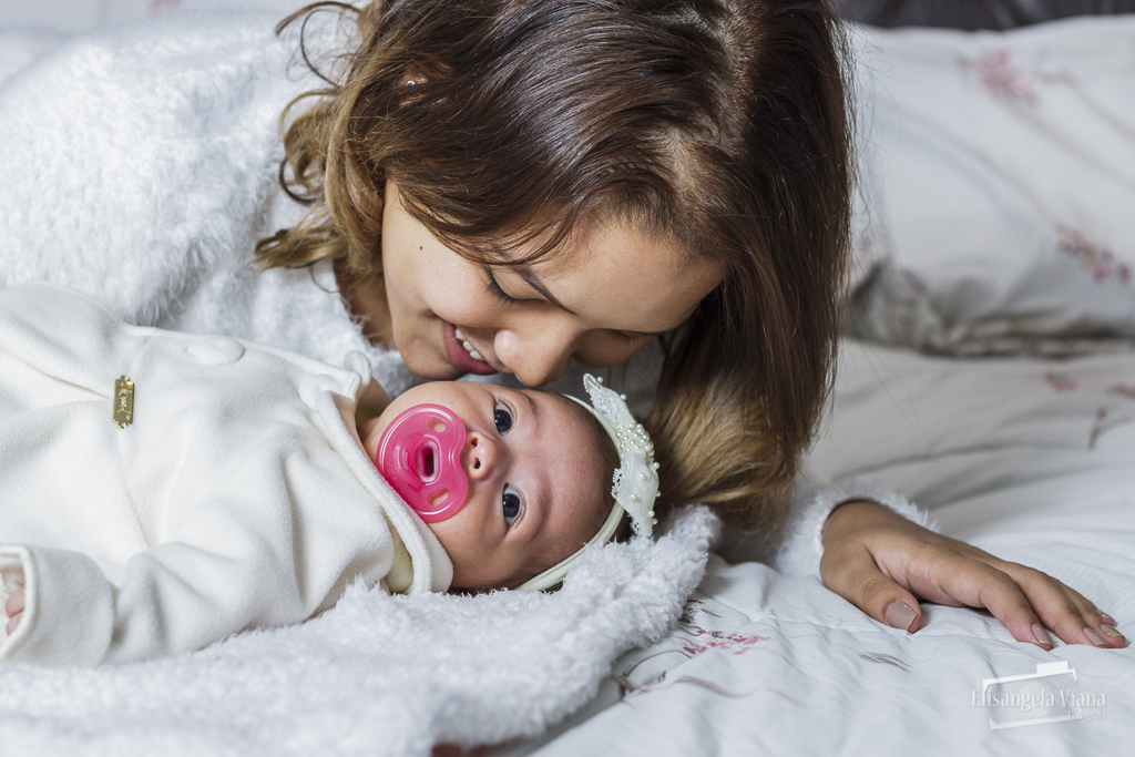 mamãe cheirando bebê deitado