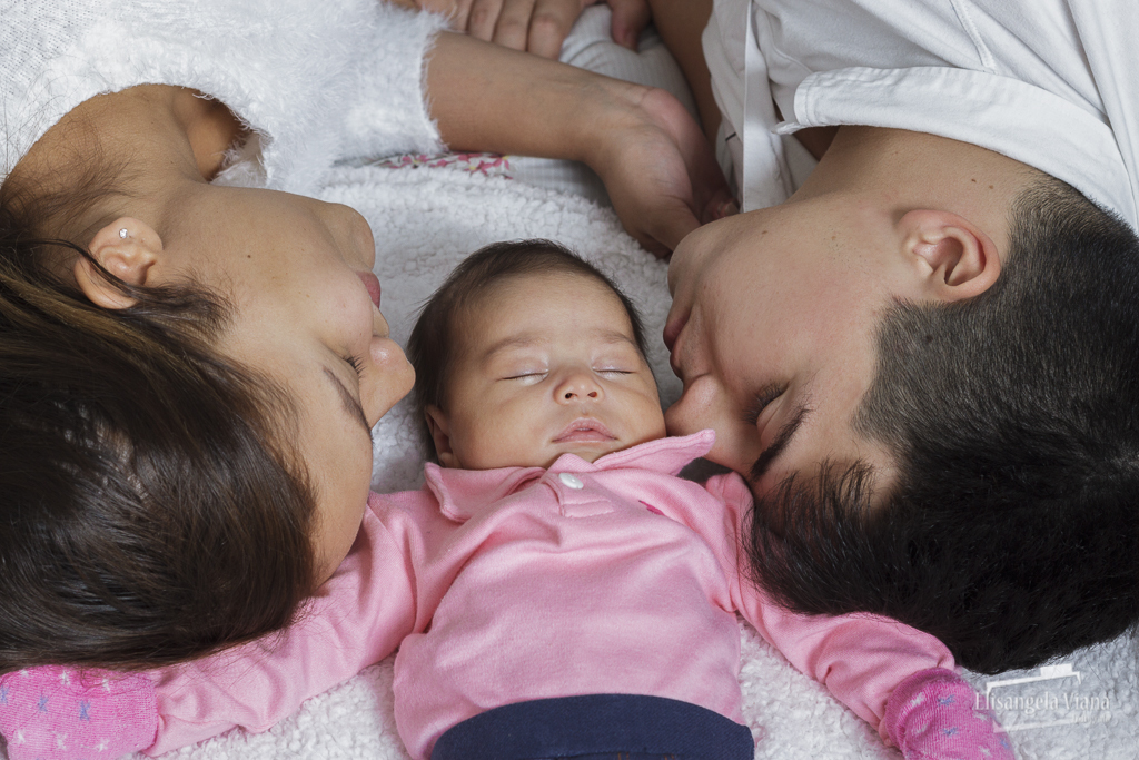 bebê deitada entre os pais