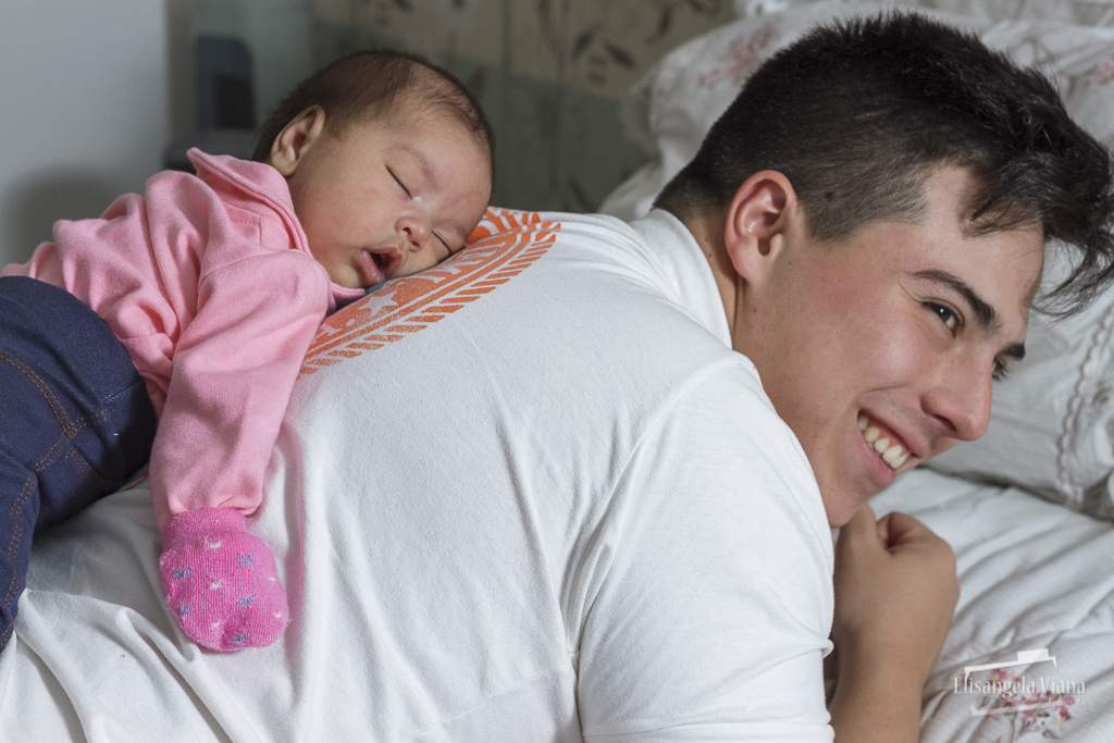 bebê deitada nas costas do pai